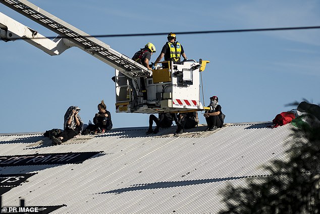 Police officers were forced to use an aerial platform to remove the demonstrators from the factory roof