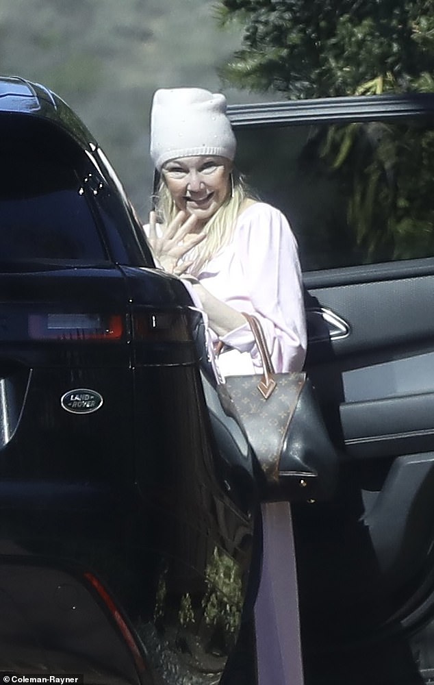 Without make-up and looks healthy and well-groomed.  Heather was dressed for comfort in a soft pink lounge suit and matching hat and carried a Louis Vuitton bag