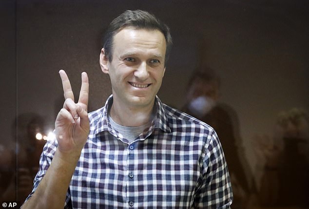 FILE - Russian opposition leader Alexei Navalny gestures while standing in a cage in the Babuskinsky District Court in Moscow, Russia, Saturday, February 20, 2021