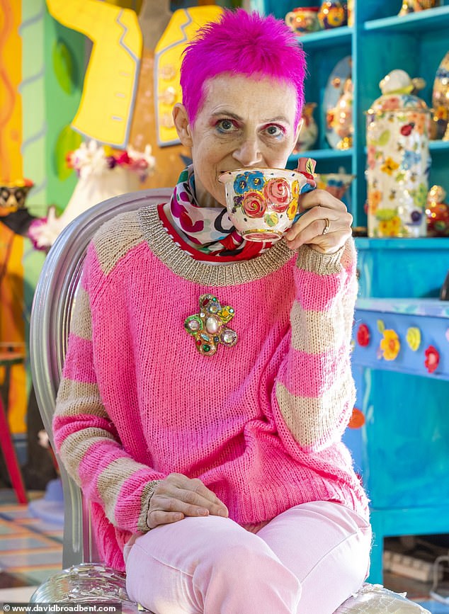 Pictured: Artist Mary Rose Young drinks a cup of tea in her pottery studio at home, with a multi-colored ceiling