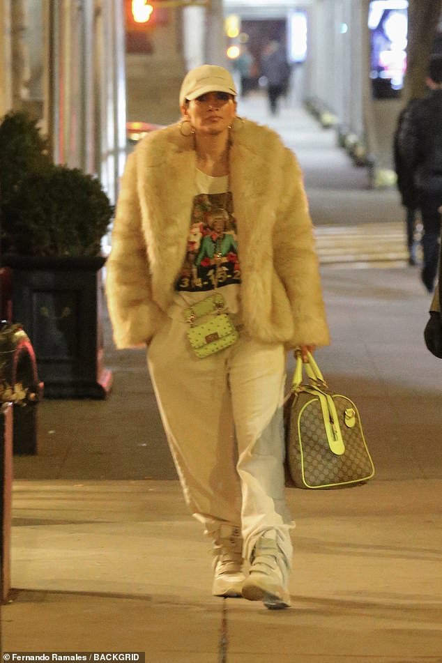 Jennifer Lopez, 54, stayed warm as she stepped out in New York City on Thursday, wrapping up in a luxurious cream-colored fur coat, under which she wore a T-shirt and gray sweatpants