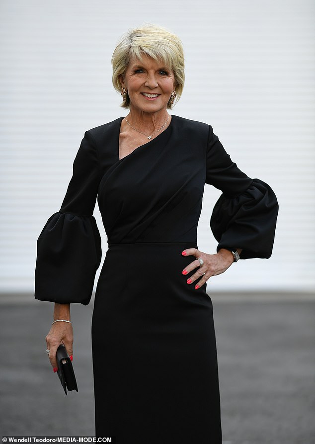 The fitted black dress wrapped around her slim figure and featured long sleeves with puff details