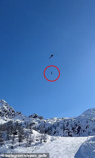 The helicopter is seen transporting goods under a perfect blue sky over the Aprica ski resort in the Sondrio province of northern Italy