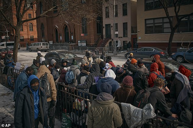 Migrants collect clothing in cold weather last month as mutual aid groups distribute food and clothing near the Migrant Assistance Center at St. Brigid Elementary School in New York