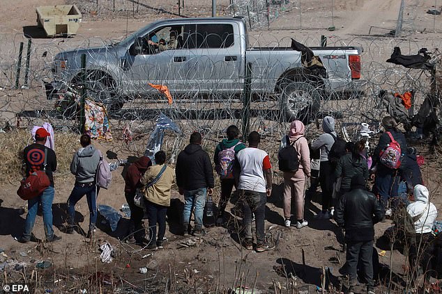 US soldiers intercept migrants as they attempt to cross a fence in the Mexican-American line