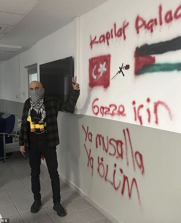 The man stood next to a drawing of the Palestinian flag and the words 