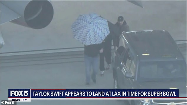 Swift was protected by an umbrella as she landed in Los Angeles on Saturday evening