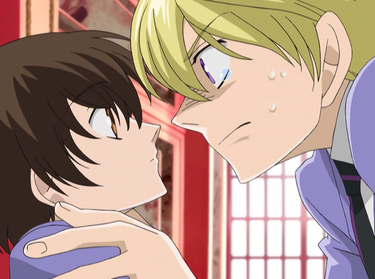 Ouran High School Host Club Characters - Tamaki, on the right, grabs Haruhi by the shoulders.  She looks unfazed, but looks back up at him.  His expression is intense.