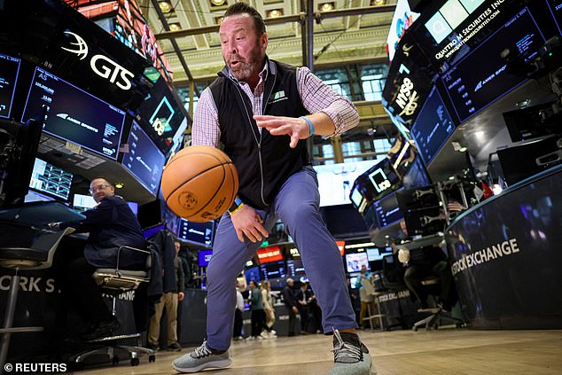 The S&P 500 nearly reached an all-time high of 5,000 points.  Pictured is a trader on the New York Stock Exchange dribbling a basketball