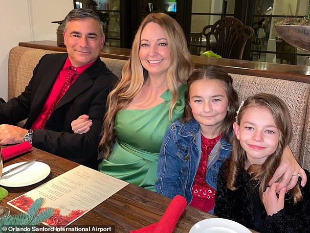 Orlando Sanford Airport police officer Andrew Tedesco is suing a Florida school board after his wife Nicole was killed after being struck by lightning.  They are pictured with their two daughters, 10-year-old Ava and 8-year-old Gia