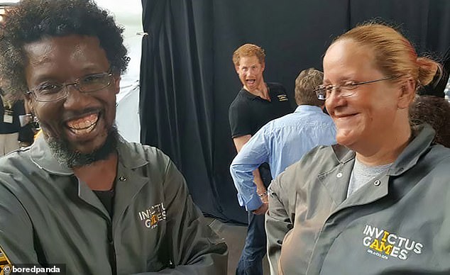 Happy as Harry!  The Duke of Sussex showed his silly side as he stuck his tongue out behind two Invictus Games employees in this photo taken in Toronto