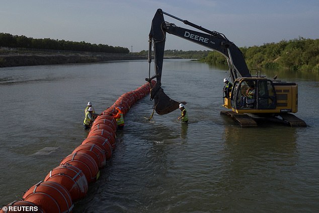 Workers collect a series of buoys to stop migrants from crossing the Rio Grande River at the international border with Mexico in Eagle Pass, Texas, U.S., July 27, 2023