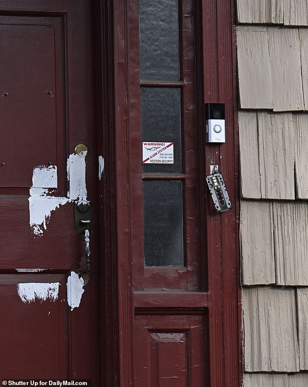 Scattered, unfinished white paint was also left on the home's red front door, next to a key lock holder that had been ripped off its hinges