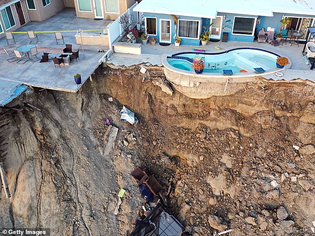 An aerial view of a remaining swimming pool at the edge of a hillside landslide caused by heavy rain, which caused four ocean-view apartment buildings to be evacuated and closed due to unstable conditions, on March 16, 2023 in San Clemente, California