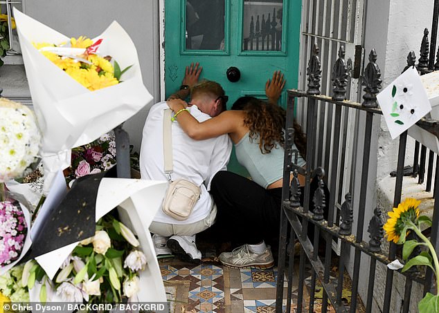 Mourners spend time at the front door of Mr Baird's home - where he and his partner Luke Davies were allegedly murdered on February 19.