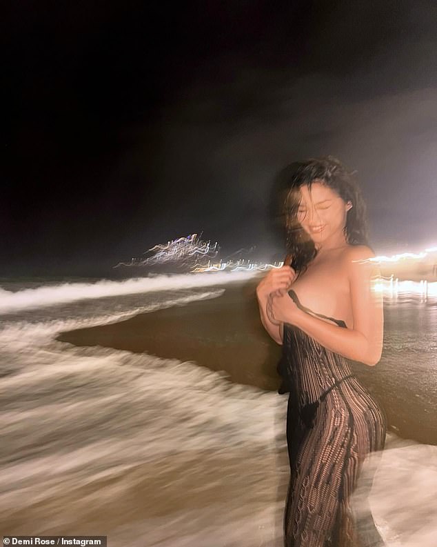 The glamor model - who dated Tyga in 2016 - shows off her very perky bum as she gets snapped from behind in front of the waves during a breathtaking nightscape