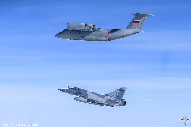 NATO said French fighters were redeployed to a new mission immediately after the first incident, intercepting a Russian AN-72 flying in international airspace north of Poland.  Pictured: A French jet beneath a Russian AN-72 in an image released by NATO