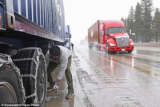Mangal Singh parks his truck near I-80 to put chains on the wheels of his truck in preparation for the snowstorm over the Sierra Nevada on Thursday, February 29, 2024 in Truckee, California.  A storm in the Pacific Ocean with strong winds and heavy snow. According to forecasters, it will be the strongest of the season.  (AP Photo/Andy Barron)