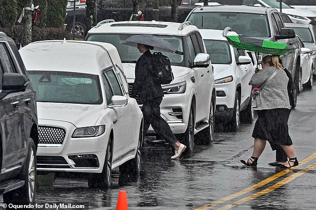 Mourners arrived at the church during a heavy rainstorm on Friday to pay tribute to Riley