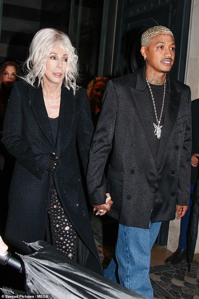 The iconic singer, who is known for her love of wigs, wore a pale blonde beehive as she strolled hand-in-hand with the hunk.