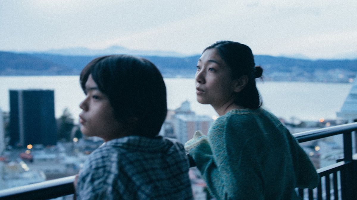 Sakura Andō and Sōya Kurokawa lean on a railing above a cityscape in Monster