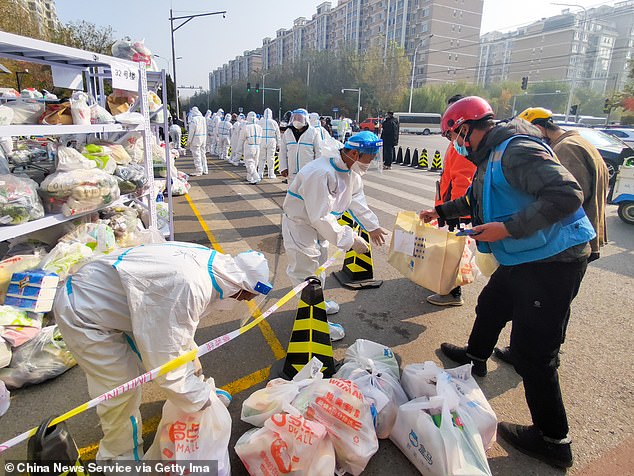 Workers manage food supplies at the Tiantongyuan residential complex where residents are under lockdown to halt the spread of the Covid-19 coronavirus on November 3, 2021 in Beijing