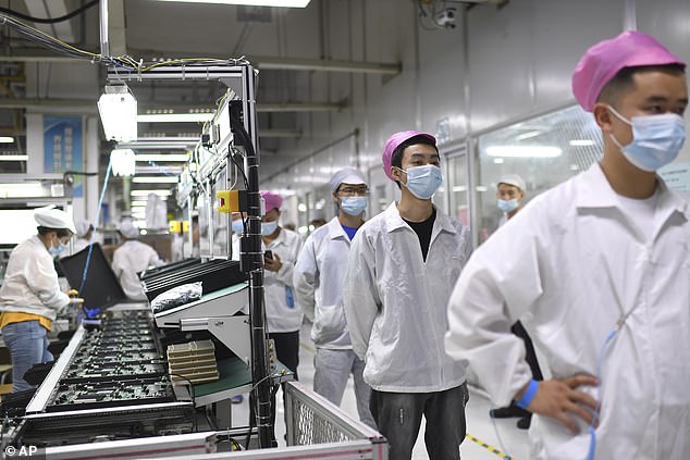 Workers line up to get tested for COVID-19 at the Foxconn factory in Wuhan in central China's Hubei province on August 5, 2021