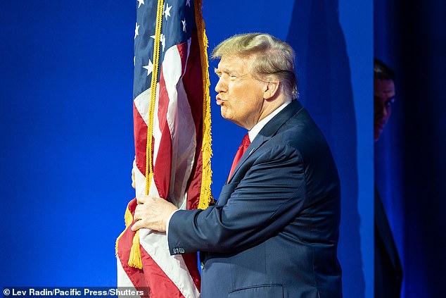 Former President Donald J. Trump kisses the American flag as he arrives on stage during CPAC Conference 2024 at the Gaylord National Resort & Convention Center in Washington DC