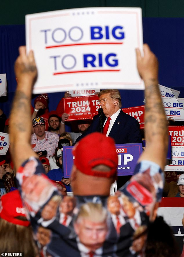 A supporter of Republican presidential candidate and former US President Donald Trump raises a sign during a rally in Greensboro, North Carolina