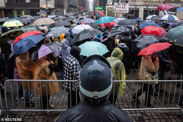 Protesters hold umbrellas as heavy rain fell in New York City on Saturday