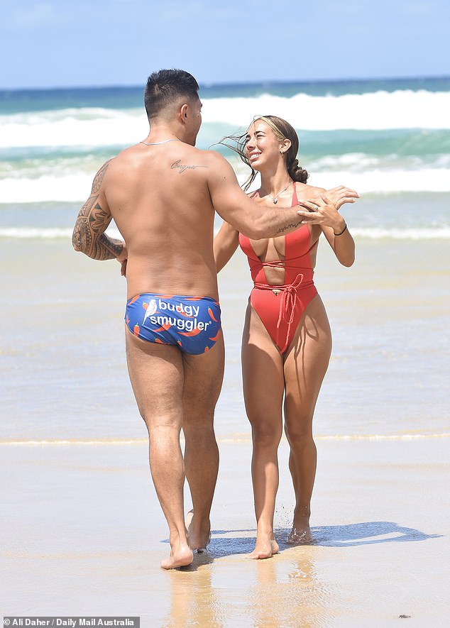 The tattooed executive assistant dared to bare for the flirty outing, wearing a red one-piece swimsuit with G-string bottoms and a plunging neckline that showed a generous glimpse of cleavage