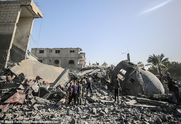 Palestinian children walk past the rubble of the al-Bukhari Mosque in Deir al-Balah, central Gaza Strip, on March 2