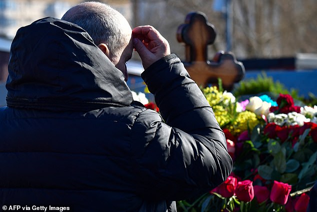 grave after dozens of supporters were arrested for flocking to the Putin critic's funeral.  Defiant mourners have braved the wrath of the Russian state, which has arrested nearly 70 people across Russia for daring to mourn the loss of the opposition figure