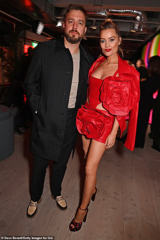 She also casually wore a matching jacket over her shoulders, which also featured a striking flower (pictured with husband Iain Stirling)