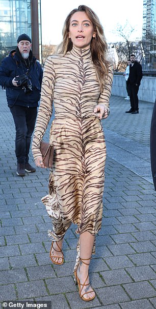 She paired the dress with brown strappy heels and a chic handbag