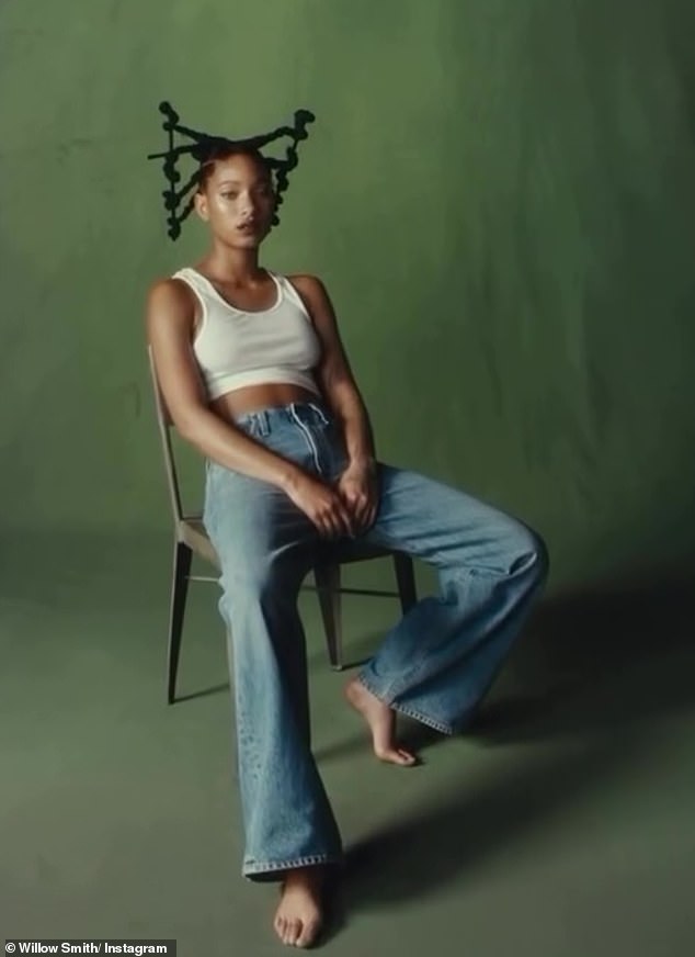 In the shot, the entertainer sat on a chair against a green background