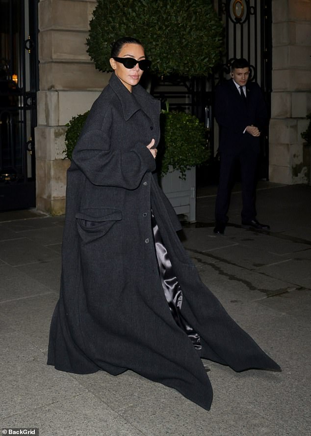 The reality star, 43, covered the figure-hugging suit with a black oversized coat, which masked most of her sexy ensemble as she headed out on the town