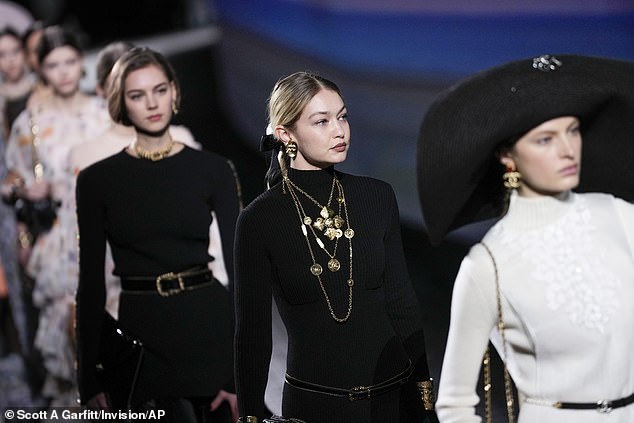 For the Chanel show, Gigi wore a long black knitted dress with a sheer skirt that was paired with a series of gold chains