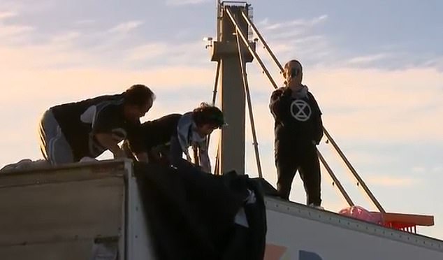 Officers used an aerial platform to safely arrest and lower the trio at 9.45am on Tuesday after they refused to get out of the truck parked on the West Gate Bridge (pictured)