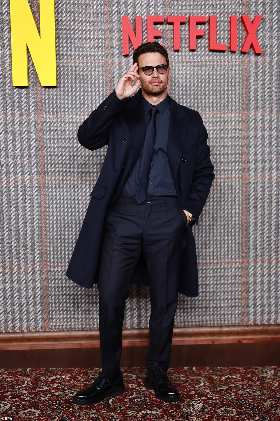 Lead actor Theo James looked suave in a navy blue shirt, matching tie and trousers, teamed with a dark trench coat and black shoes