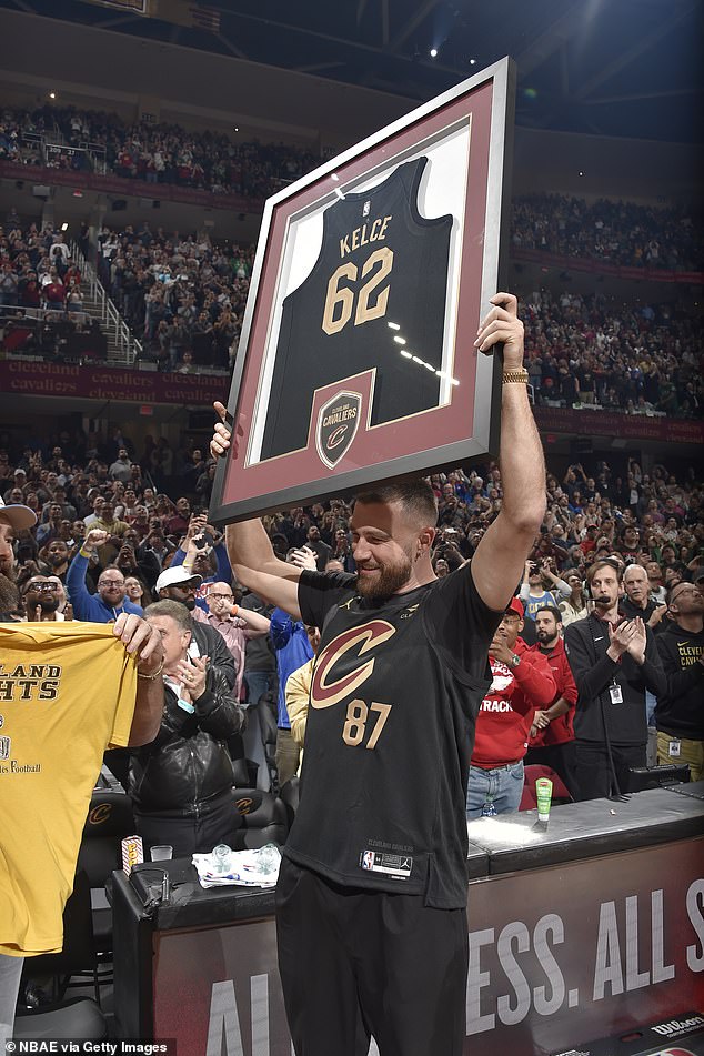 Travis proudly held up a framed No. 62 Cavs jersey in his brother Jason's other