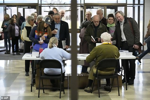 An overflow crowd lines up before attending a town meeting and voting in the primary election, Tuesday, March 5, 2024, in Stowe, Vt.