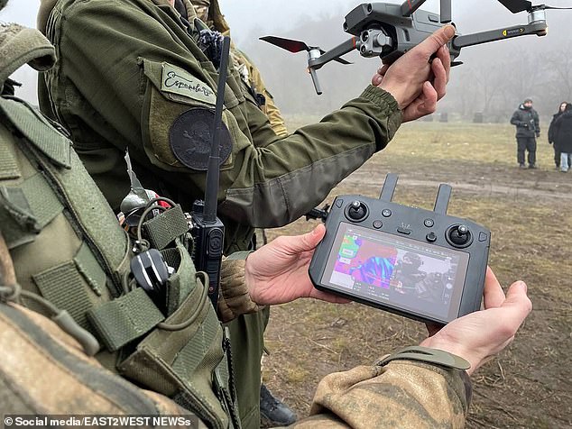 A drone operator, pictured with an Española badge on his arm, shows off his equipment