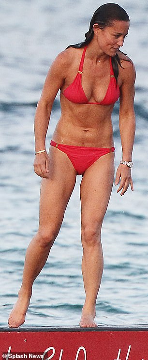 She enjoys a dip in the Caribbean ocean in a skimpy red bikini