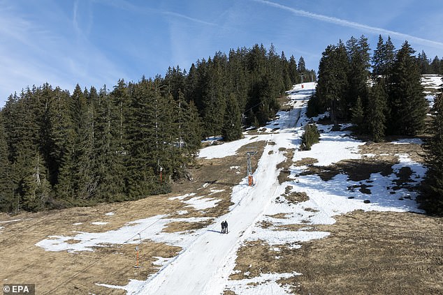 Skiers use a lift on a partially snow-covered ski slope at the Alpine resort of Les Mosses, in Ormont-Dessous, Switzerland, February 6, 2024. Mild weather in the Swiss Alps in recent days disrupted activity at alpine ski resorts