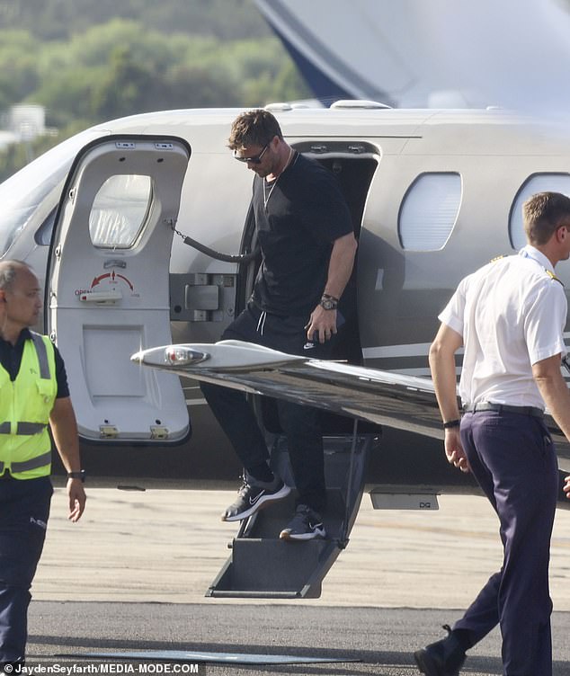 The Thor star was spotted trying to avoid the spotlight as he arrived on his luxury plane, wearing an all-black outfit with matching sunglasses