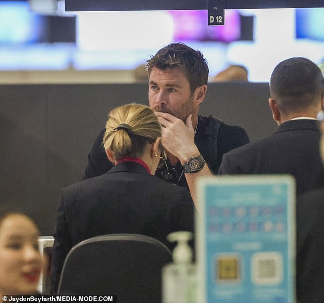 At one point, a bored-looking Chris was seen standing at the check-in desk waiting for his ticket to be processed