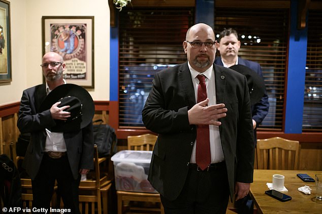 Texas Nationalist Movement President Daniel Miller makes a pledge of allegiance at a barbecue restaurant in Cypress, Texas