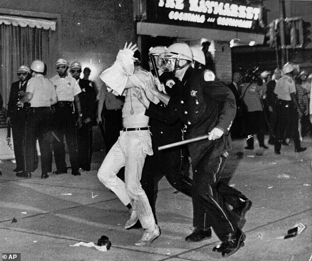 Tear gas was fired into the crowd.  Officers beat demonstrators indiscriminately.  Hundreds were sent to hospital and more were injured.  (Above) Protester with his hands on his head is led down Michigan Avenue by Chicago police on the night of August 28, 1968