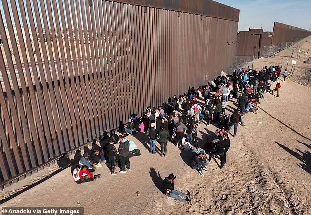 Groups of migrants of different nationalities arrive at the border fence before entering the US at El Paso